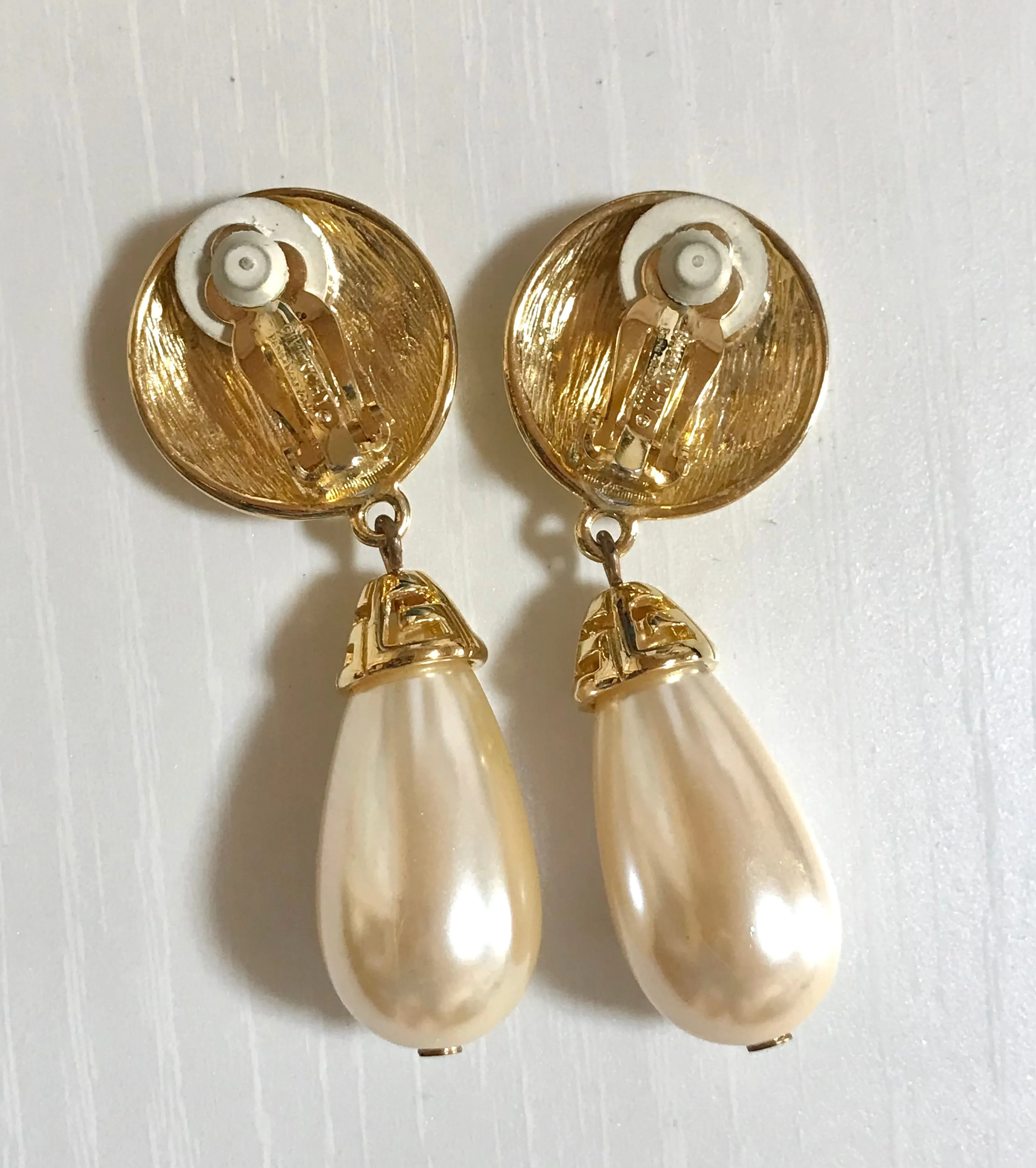 Vintage Givenchy golden round dangle earrings with teardrop faux pearl. Classic and beautiful jewelry piece.