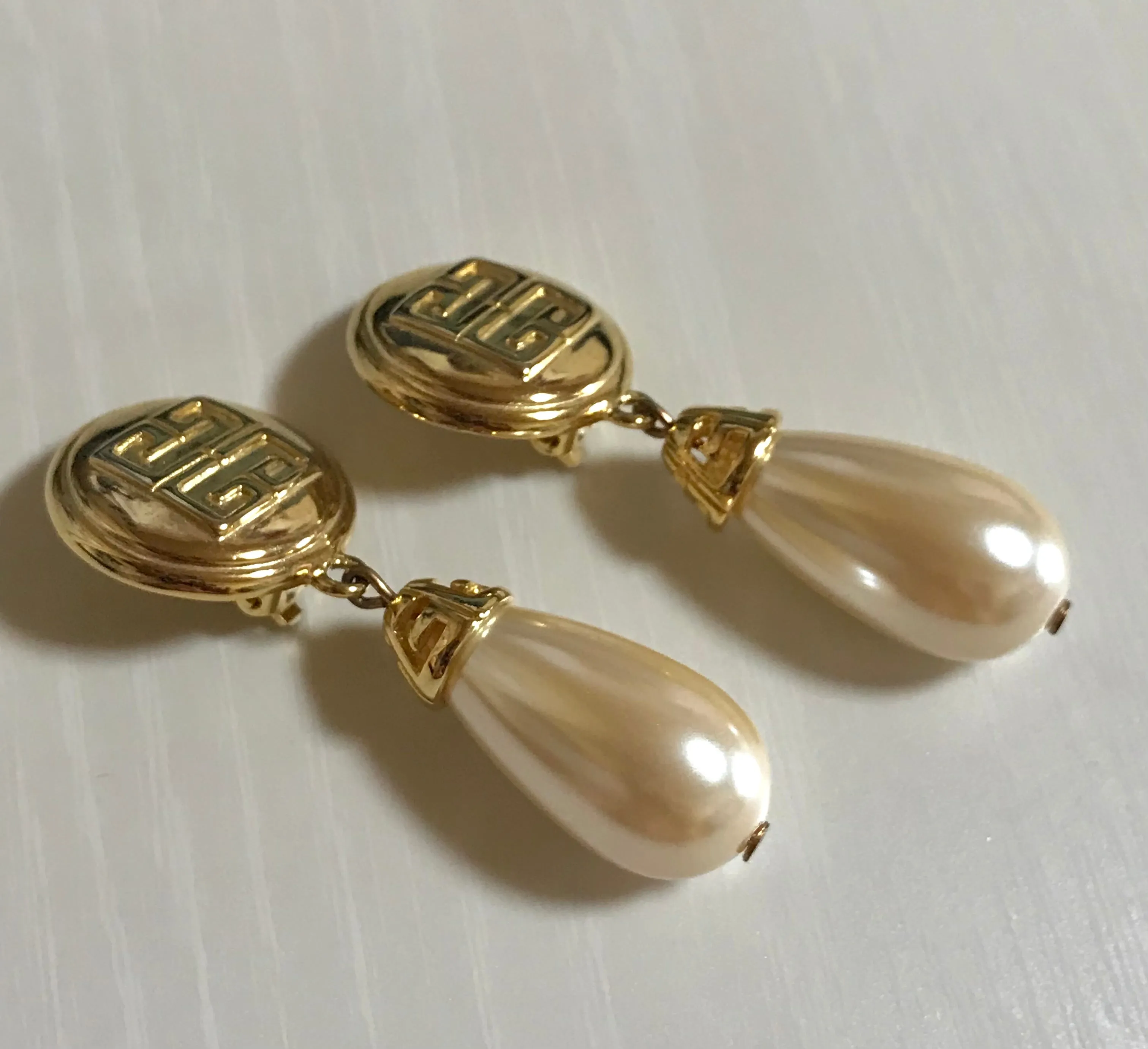 Vintage Givenchy golden round dangle earrings with teardrop faux pearl. Classic and beautiful jewelry piece.